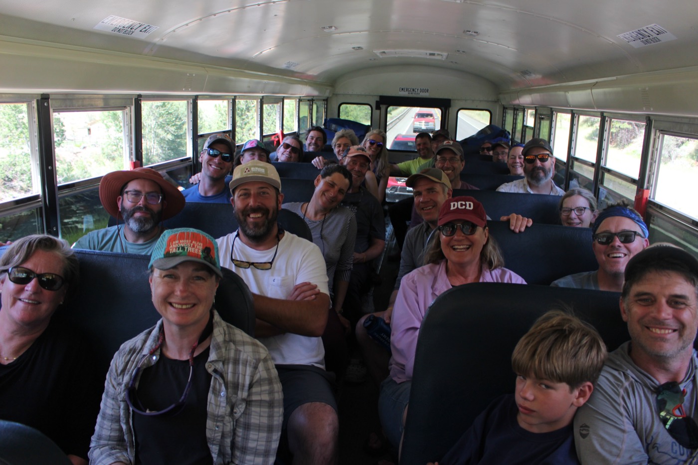 Participants smiling on the bus ride to the river