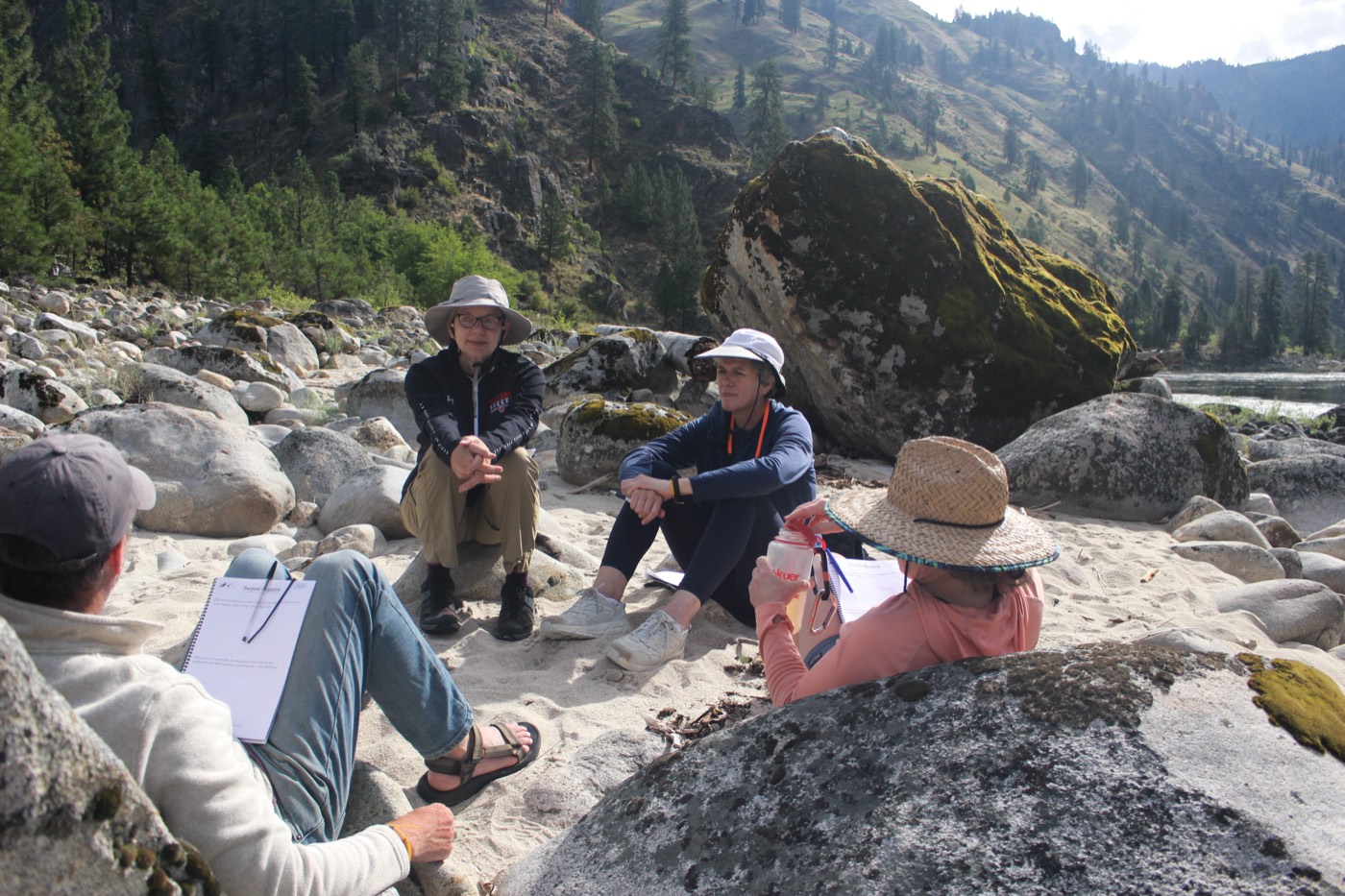 A small group reflecting among the rocks by the river