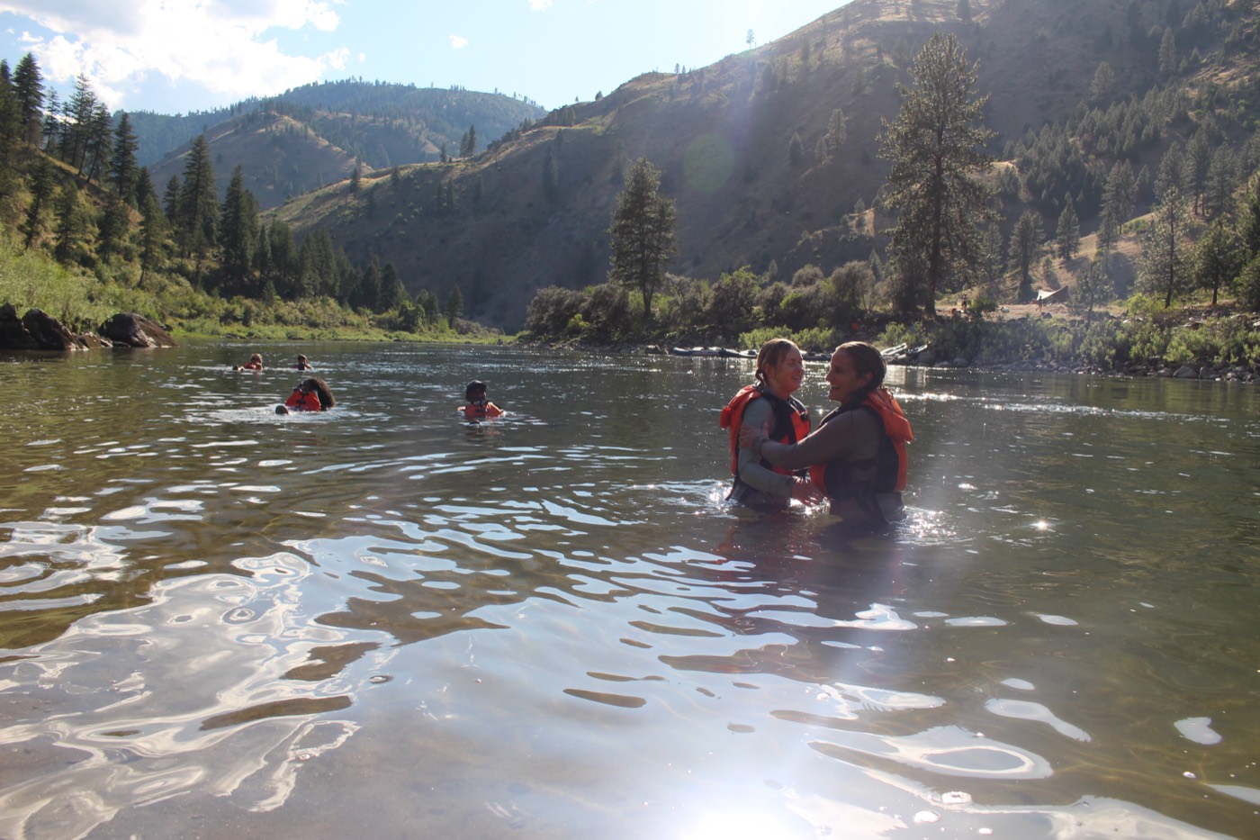 Participants swimming in the river at golden hour